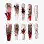 Handmade press-on nails with red gems, spider and web designs, gothic themed nail art