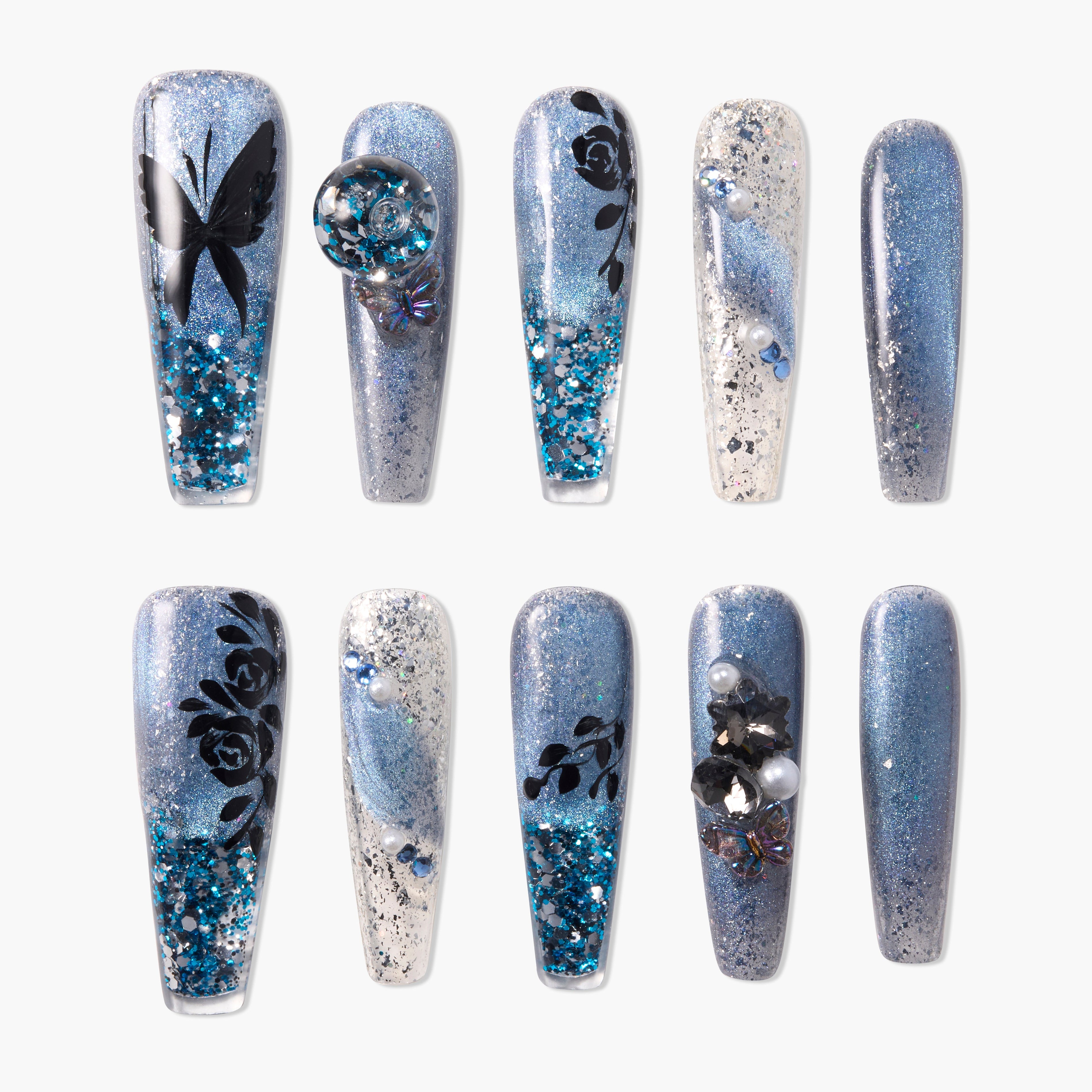 Blue glitter press-on nails with floral, butterfly, and 3D gem accents on white background