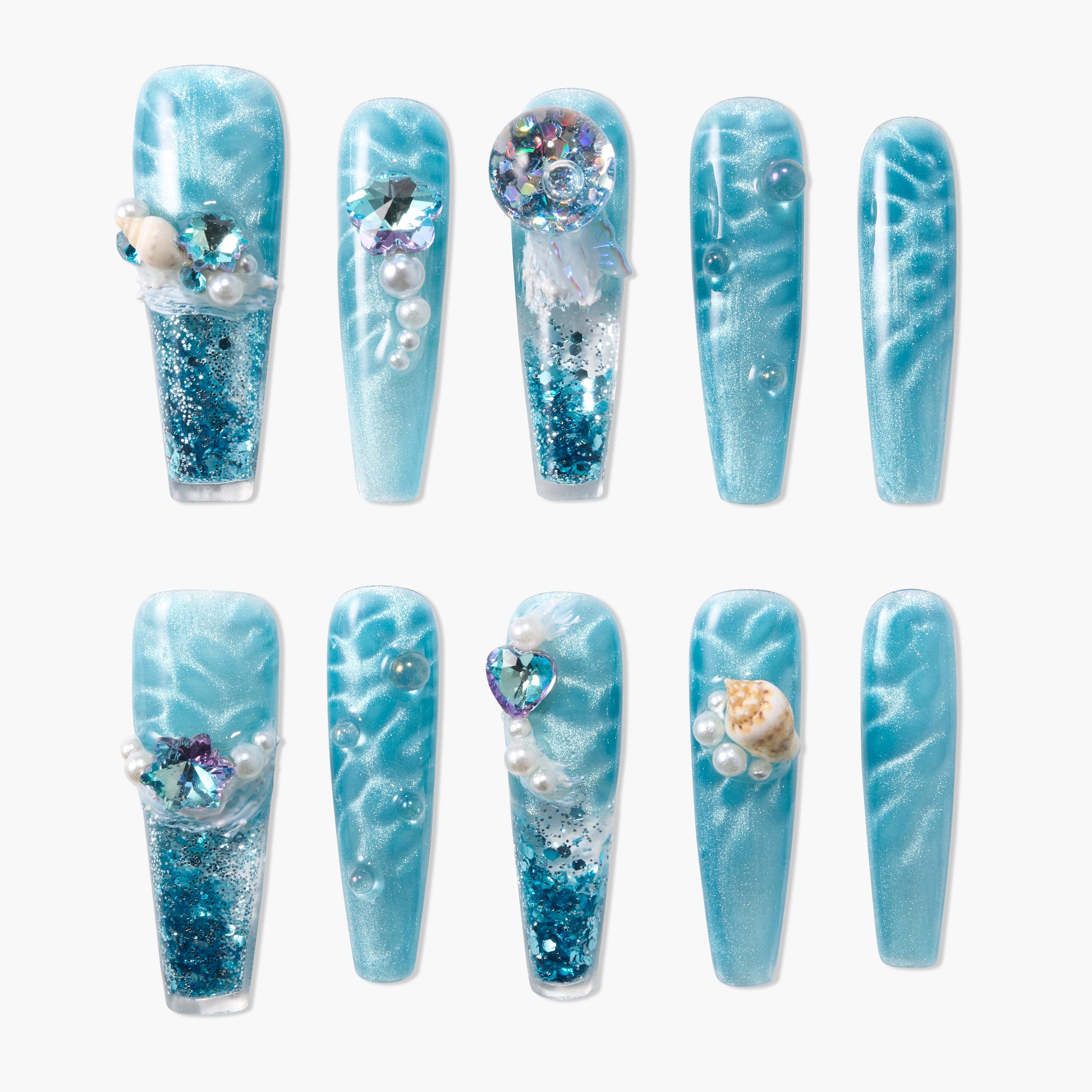 Blue press-on nails with glitter, pearls, seashells, and ocean-inspired 3D decorations