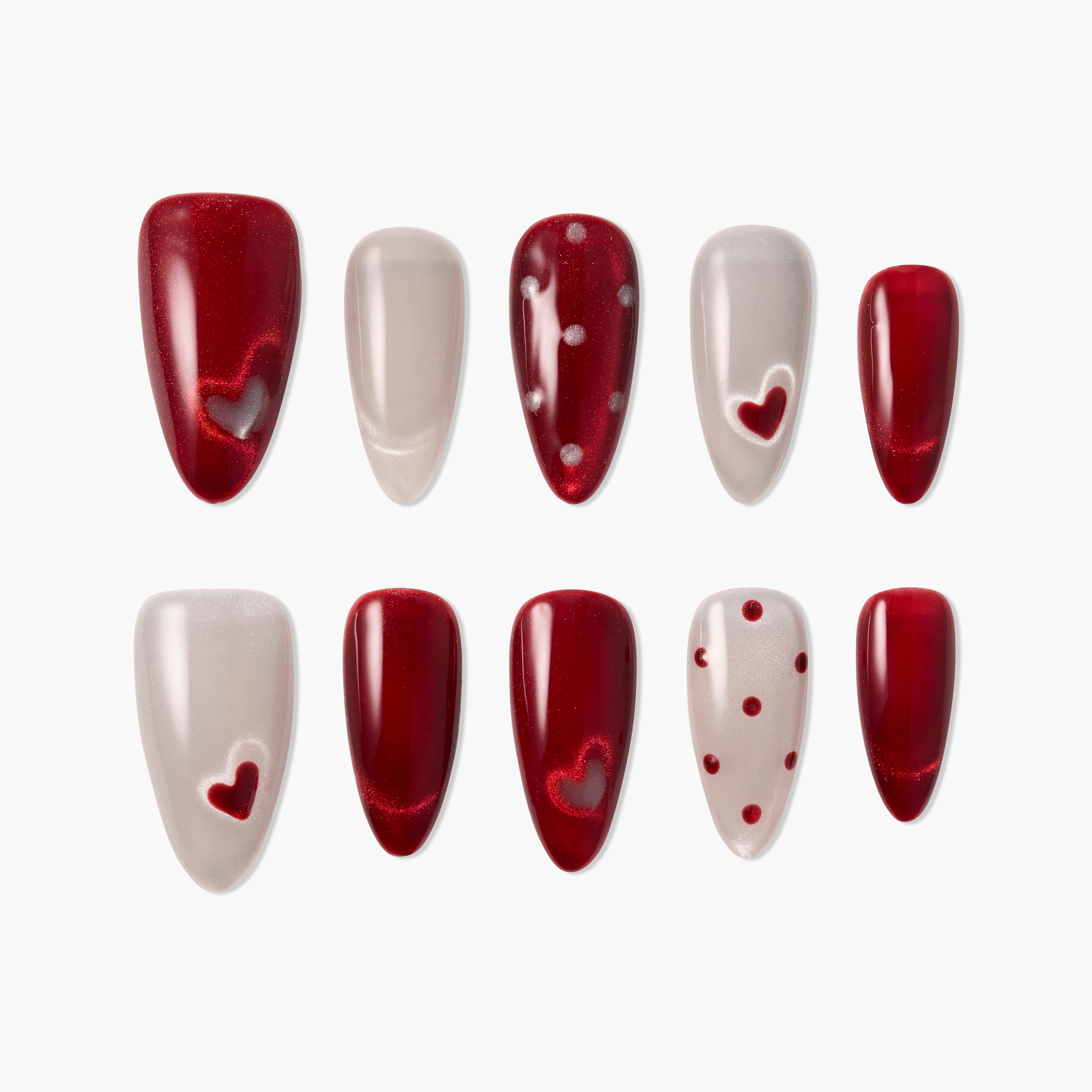 Red and nude press-on nails set, featuring heart and polka dot nail art designs.