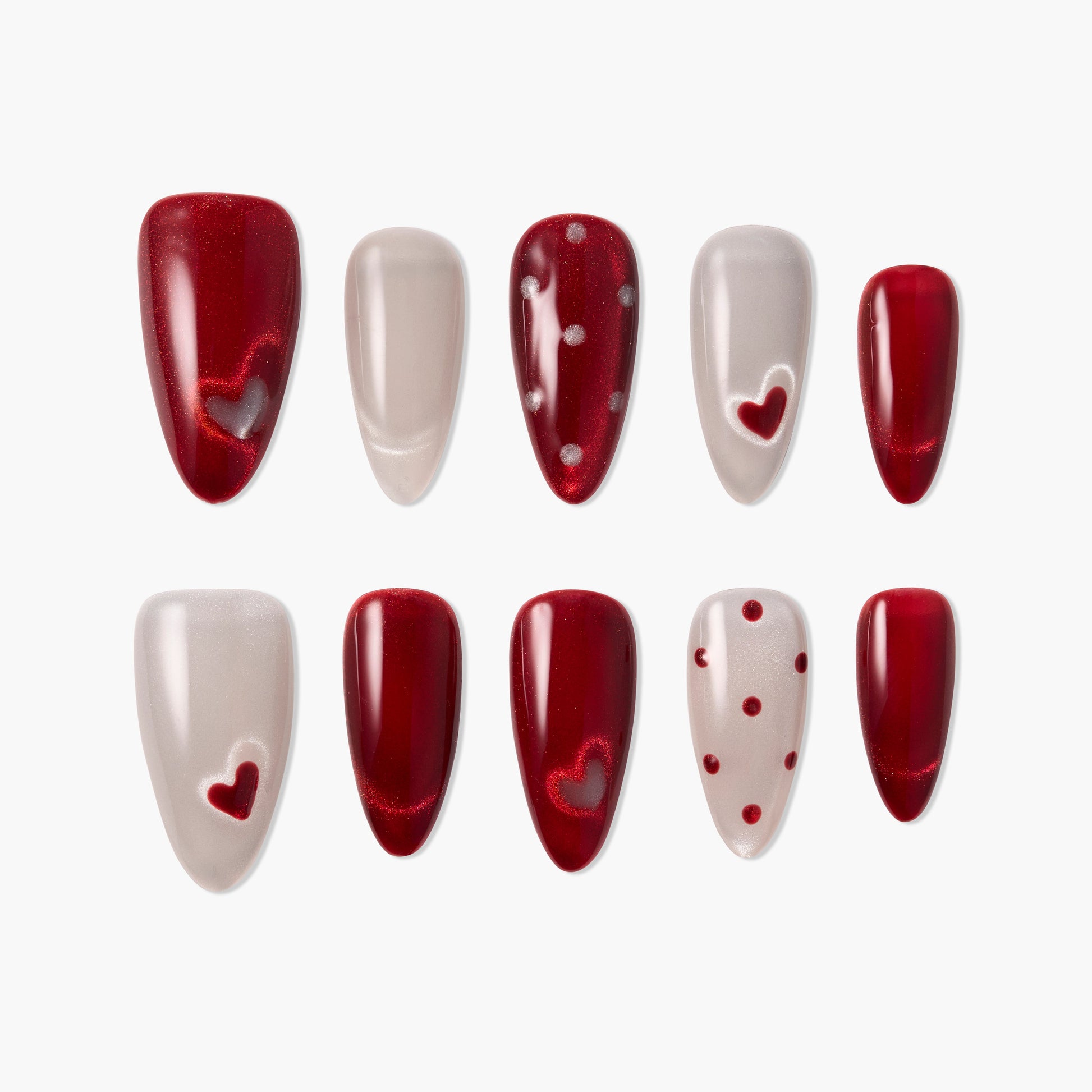 Red and nude press-on nails set, featuring heart and polka dot nail art designs.