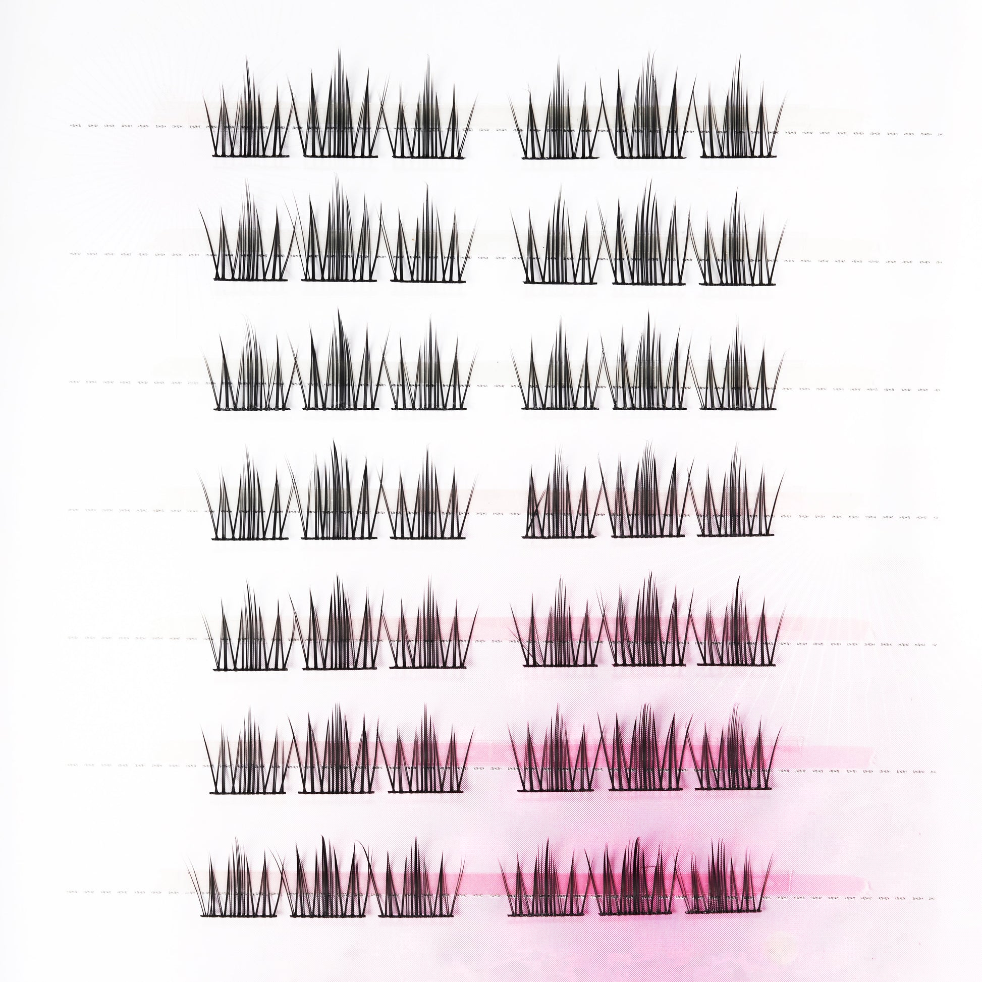 Pack of spiked false eyelash extensions arranged on a white and pink background.