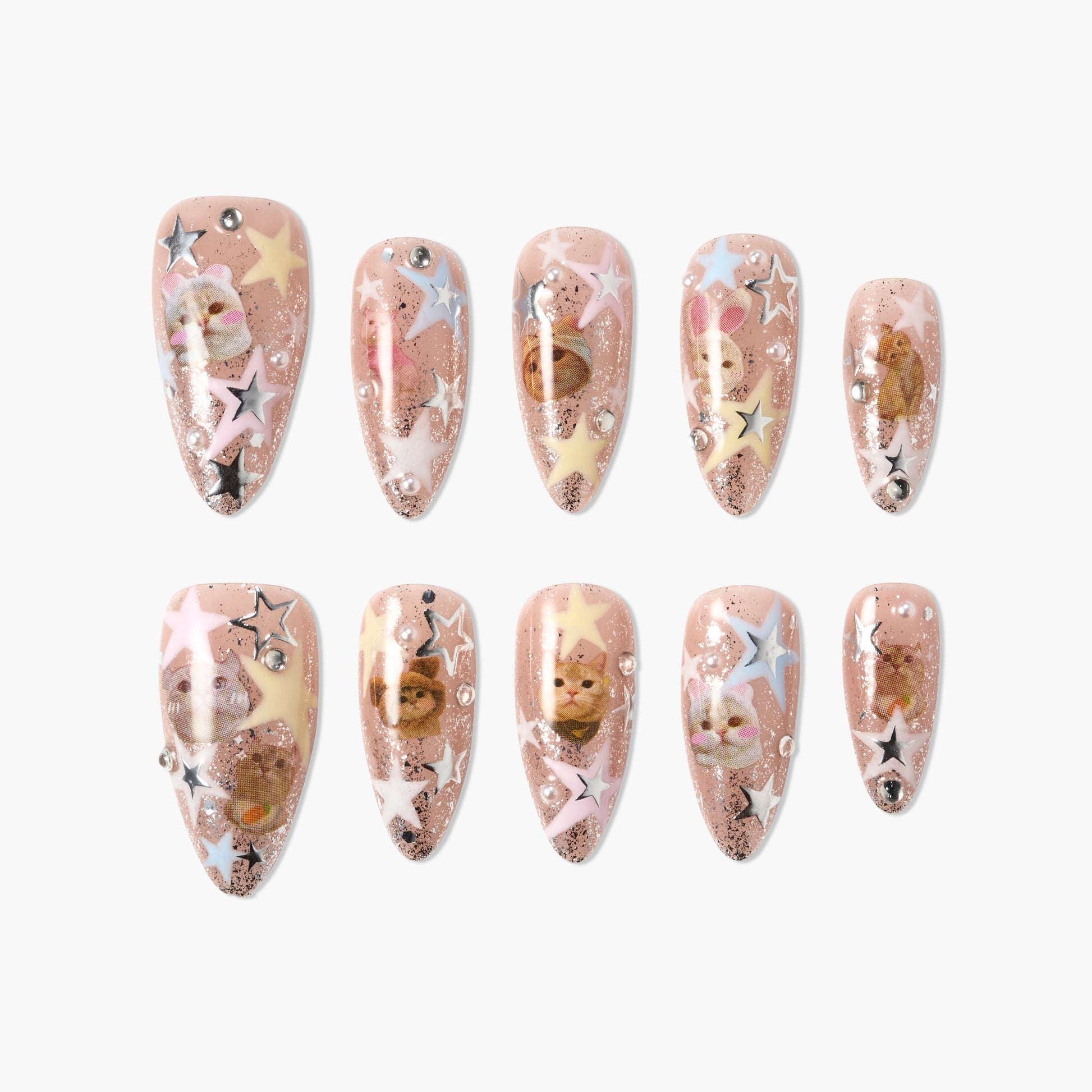 Handmade press-on nails with cat faces, pastel stars, and glitter on nude background