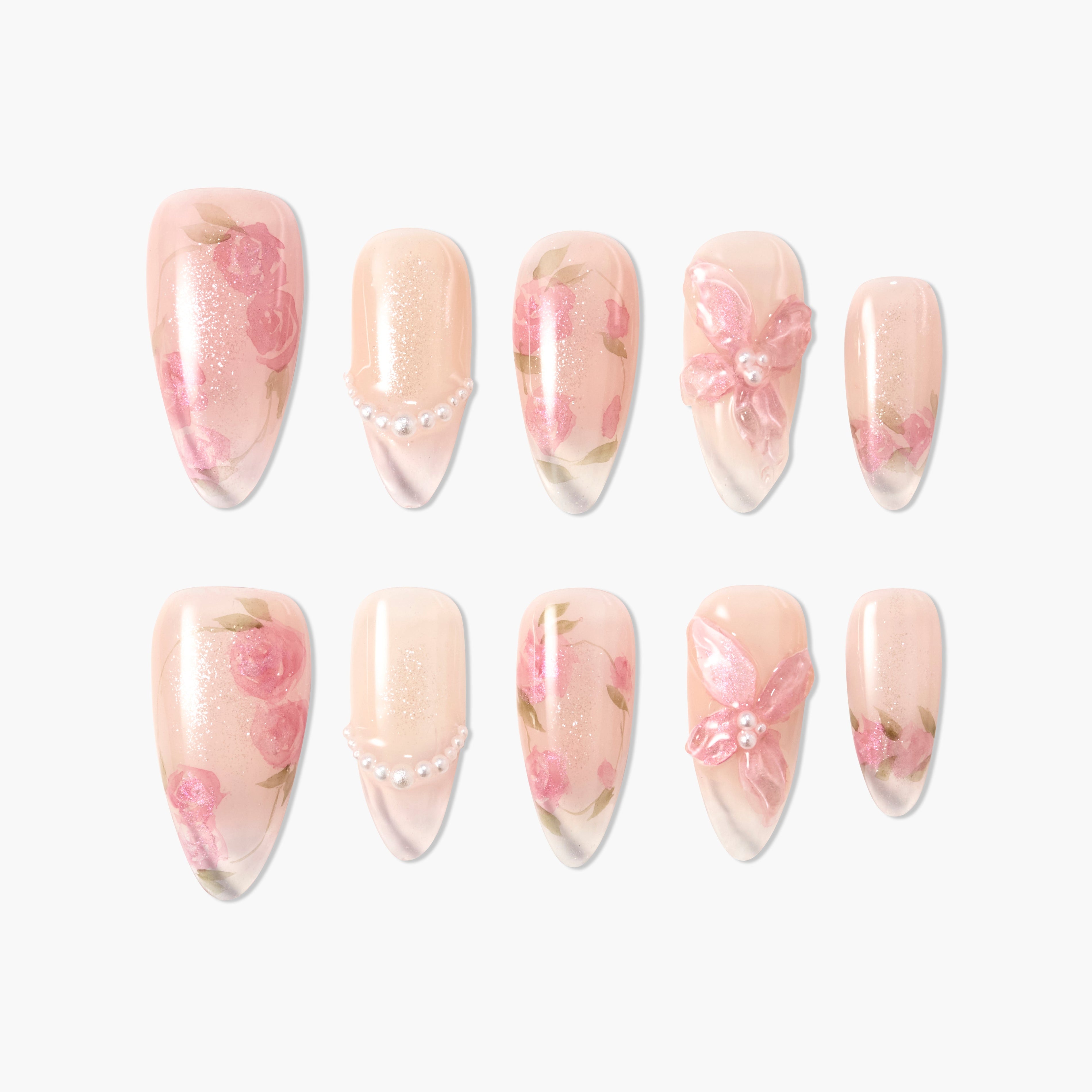Handmade press-on nails with pink floral designs, pearls, and butterfly accents on nude base