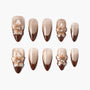Brown and gold press-on nails with 3D floral accents and shimmering French tips