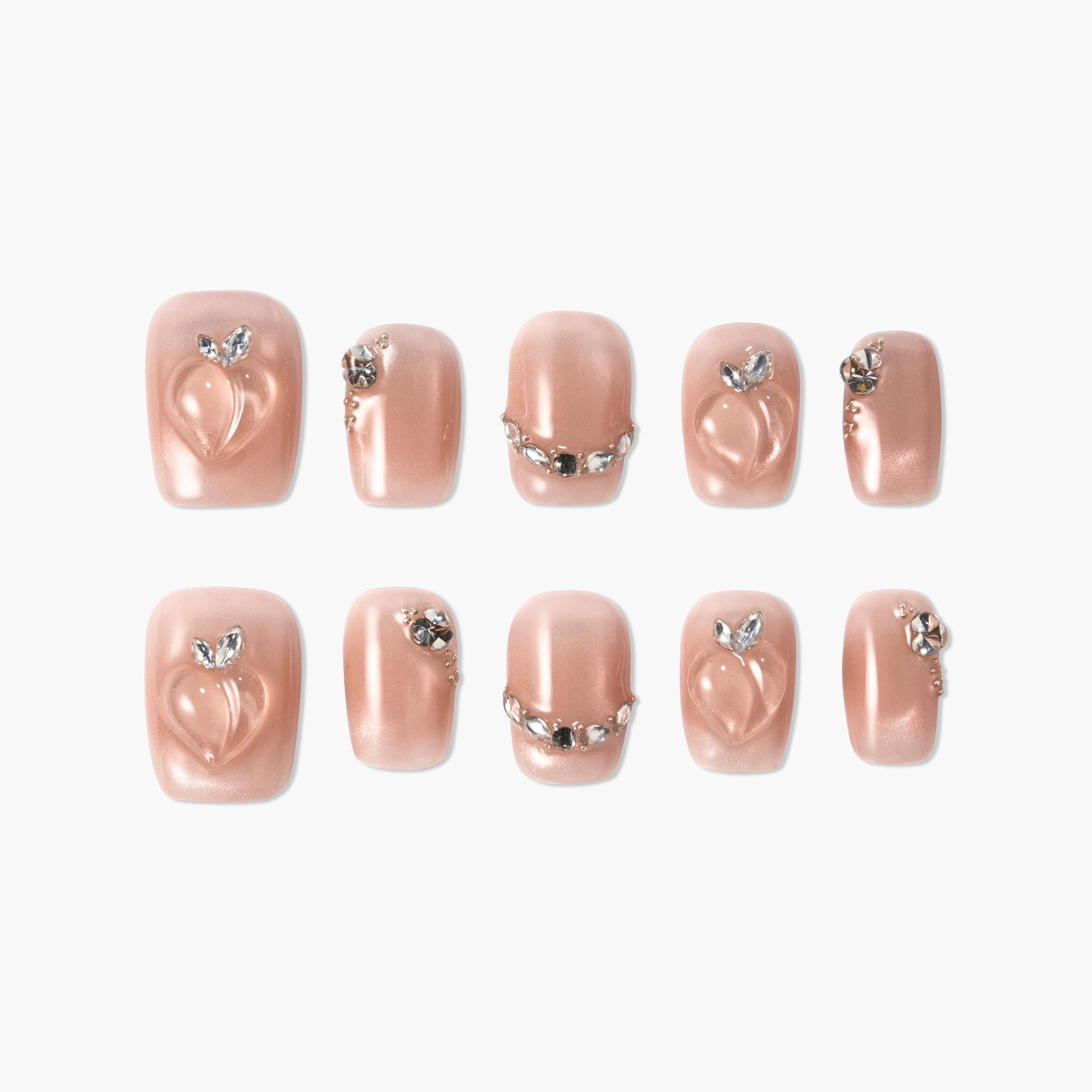 Set of glossy nude press-on nails with 3D peach design and rhinestone accents