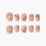 Set of glossy nude press-on nails with 3D peach design and rhinestone accents