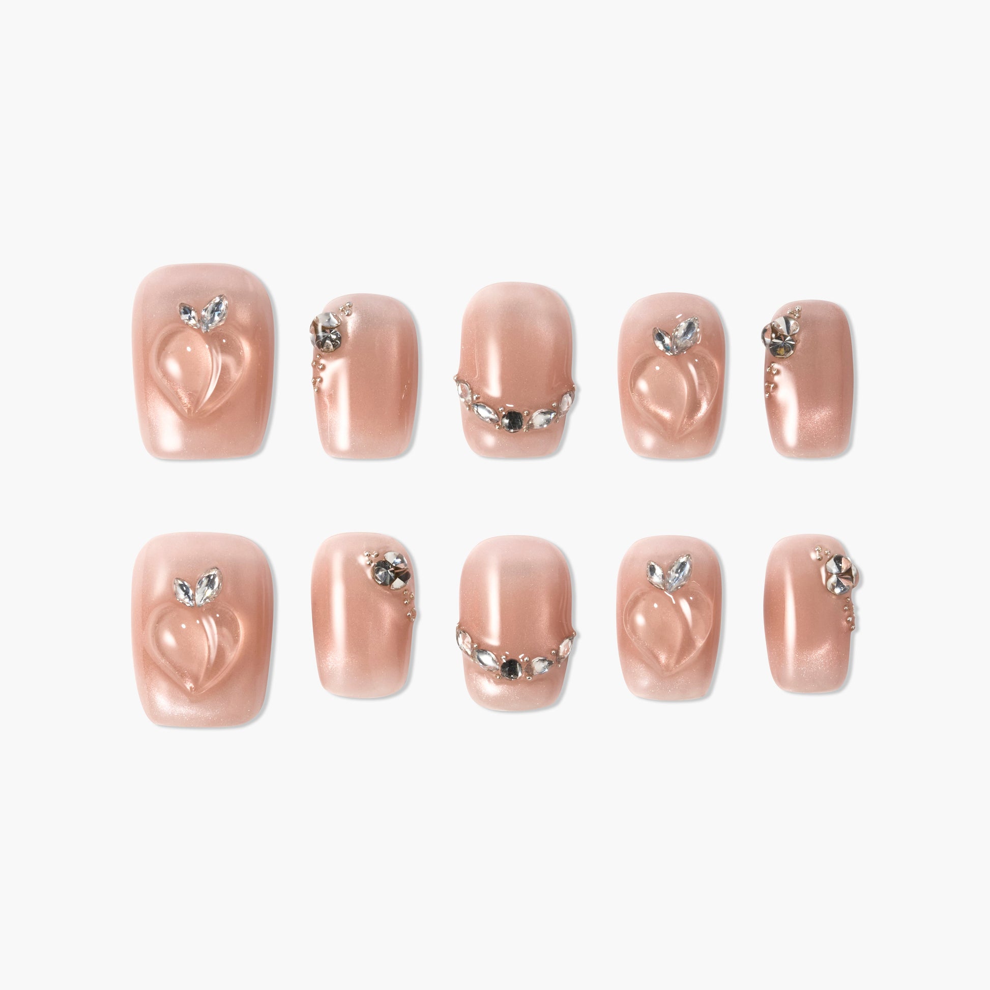 Set of glossy nude press-on nails with 3D peach design and rhinestone accents