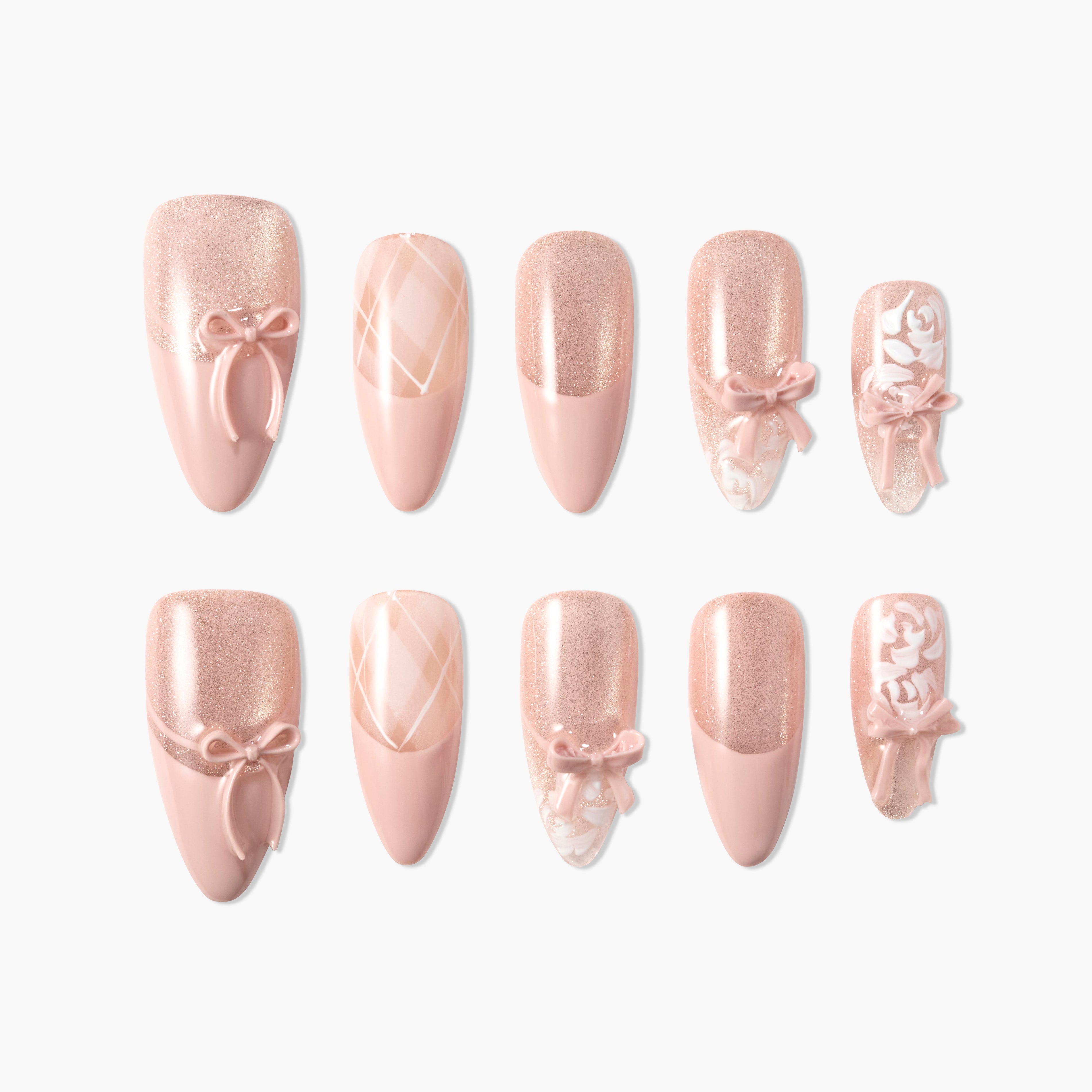 Pink press-on nails with glitter, 3D bows, plaid, and floral designs, arranged on white background.