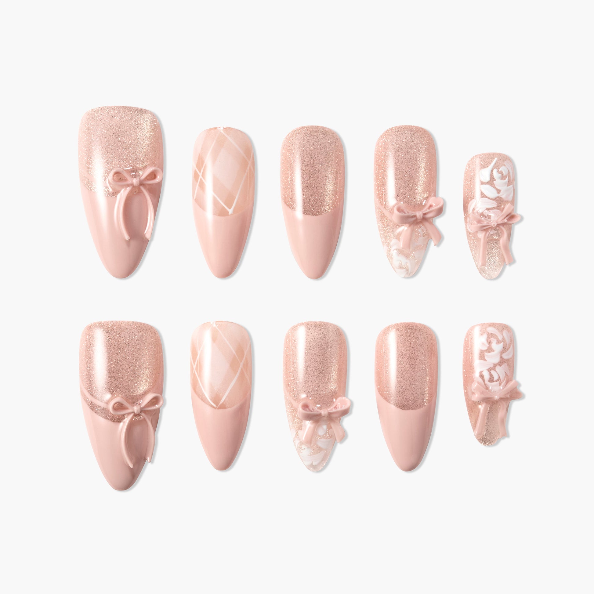 Pink press-on nails with glitter, 3D bows, plaid, and floral designs, arranged on white background.