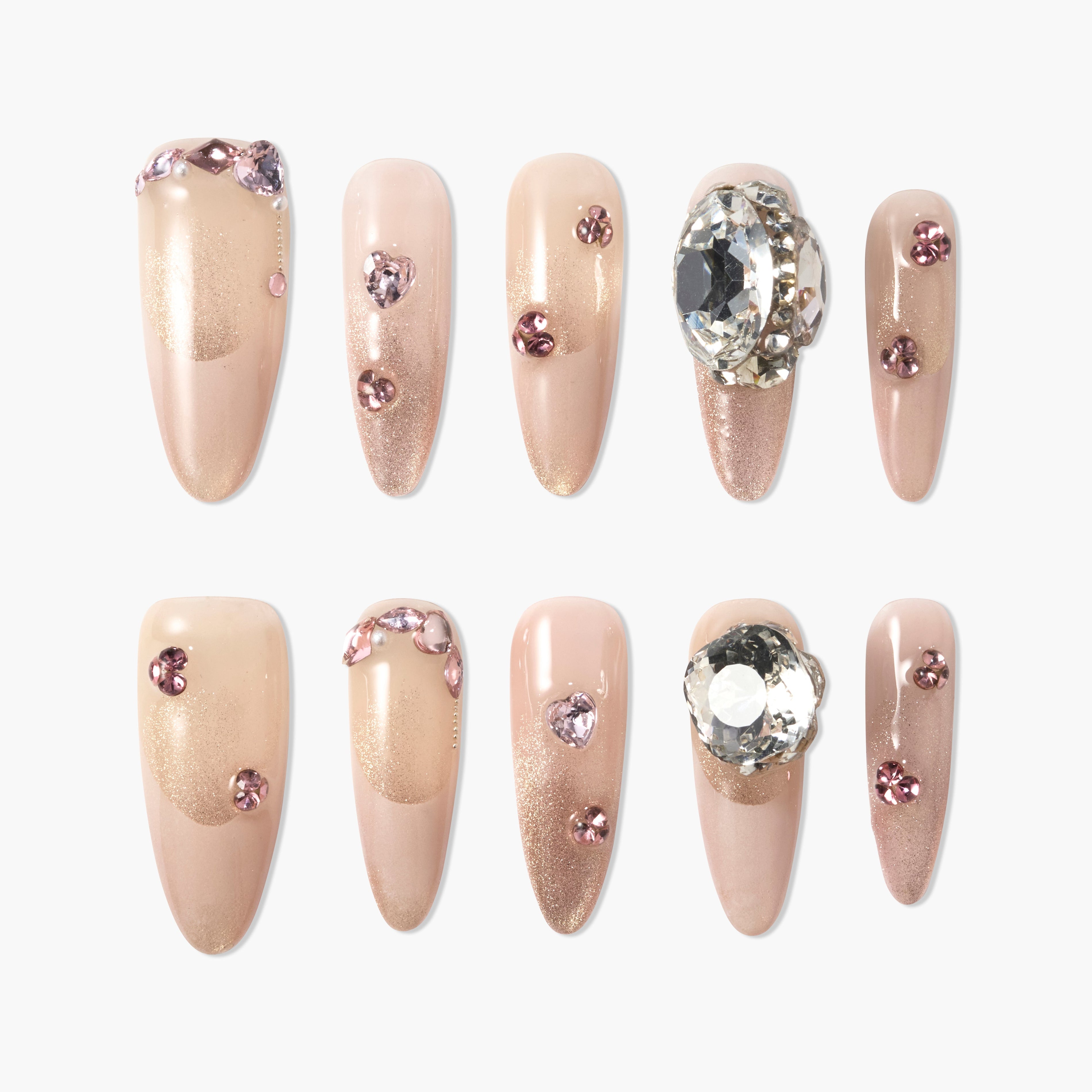 Nude glitter press-on nails with pink rhinestones and large gem accents, elegant nail art set