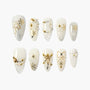 Handmade press-on nails with gold snowflake, pearl, and crystal winter holiday designs