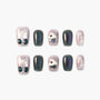 Handmade press-on nails with sparkly pink and black designs, bows, cherries, and cupcake art.