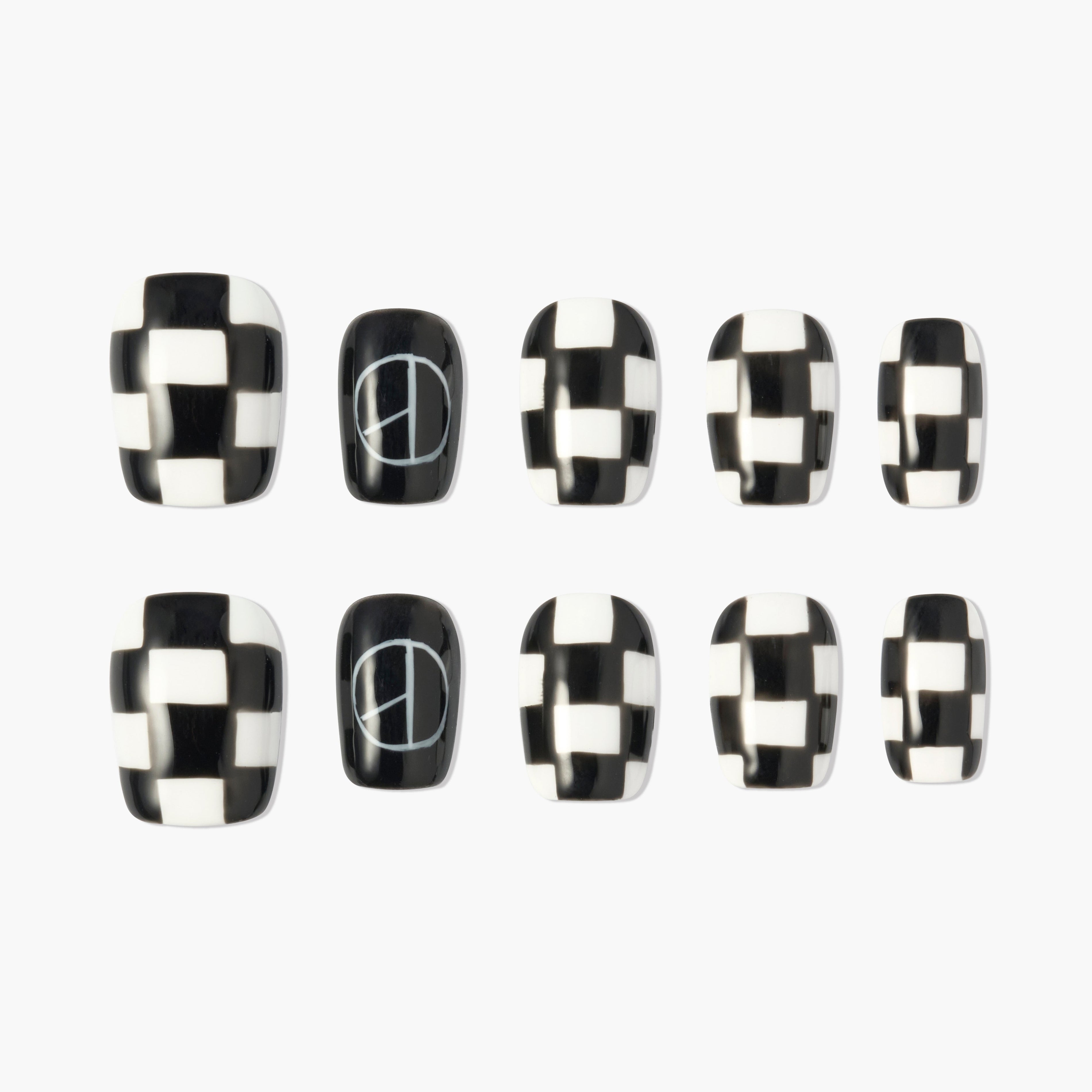 Black and white checkered press-on nails with peace sign accent design
