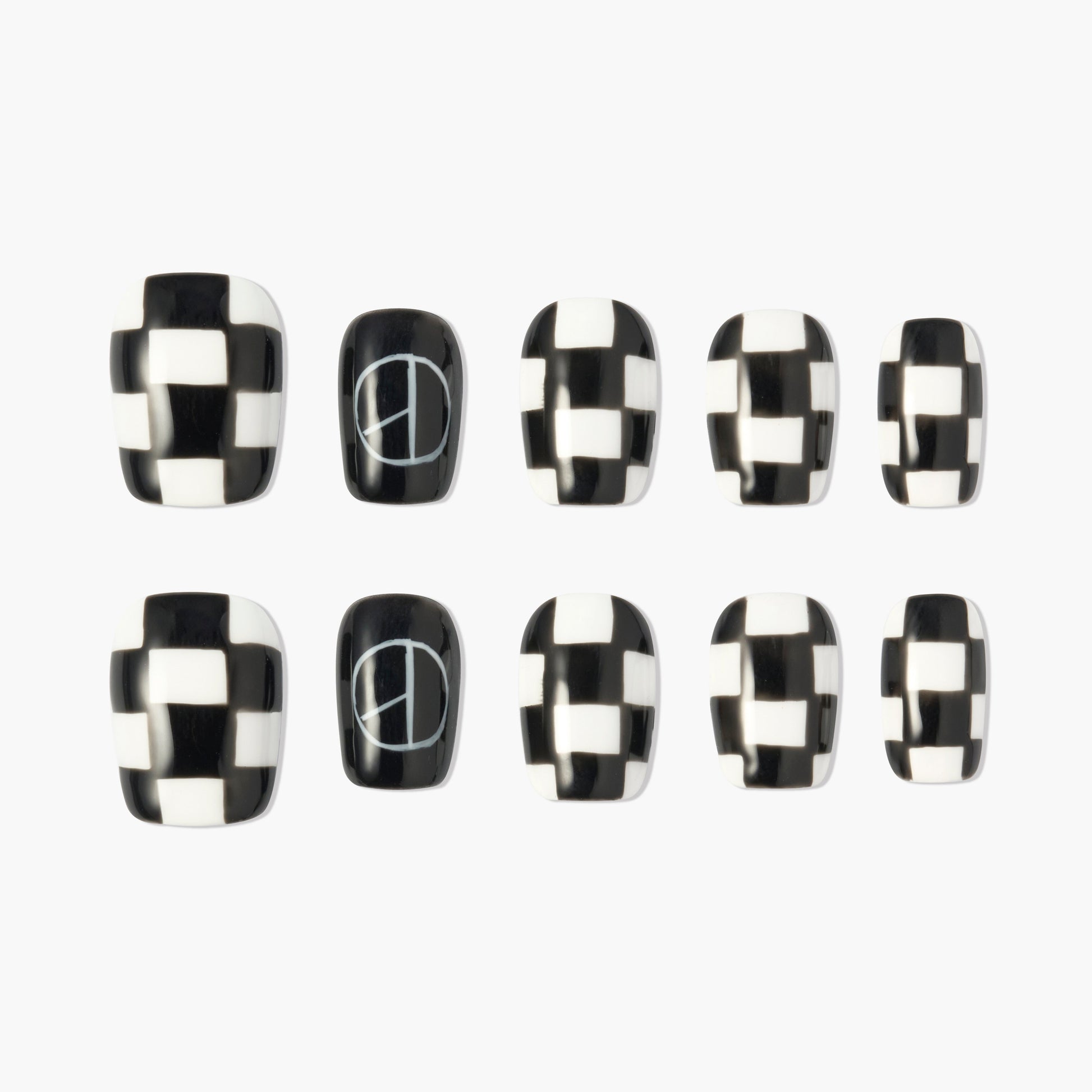 Black and white checkered press-on nails with peace sign accent design