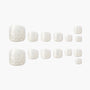 Set of glossy white marble press-on toenails arranged on a plain background