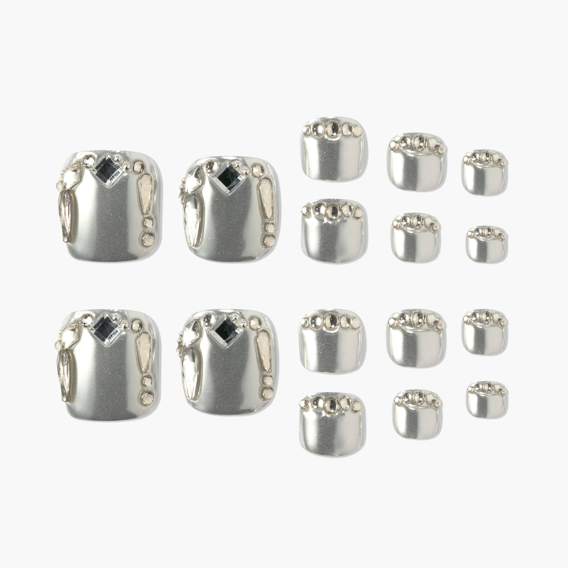 Silver press-on nails set with metallic gems and geometric accents, displayed on white background.
