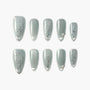 Matte sage green press-on nails with delicate silver floral designs and accent gems