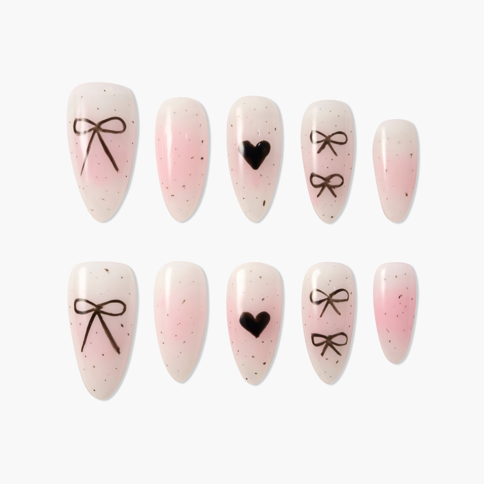 Pink and nude press-on nails with black bow and heart designs, speckled accents