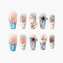 Handmade press-on nails with pastel blue bows, heart patterns, and 3D bunny accents