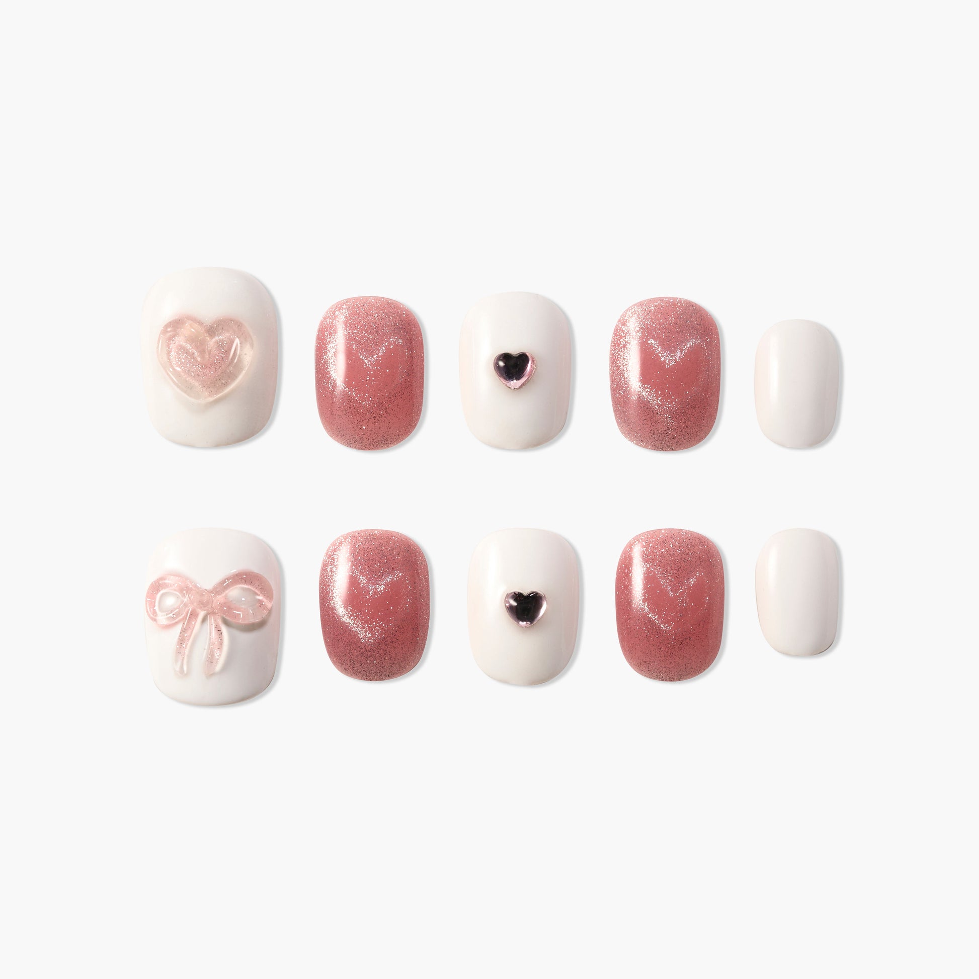 Handmade pink and white press-on nails with glitter, heart and bow designs, arranged on a white background.