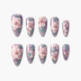 Handmade press-on nails with pink floral design and pearl accents on a shimmery lavender base