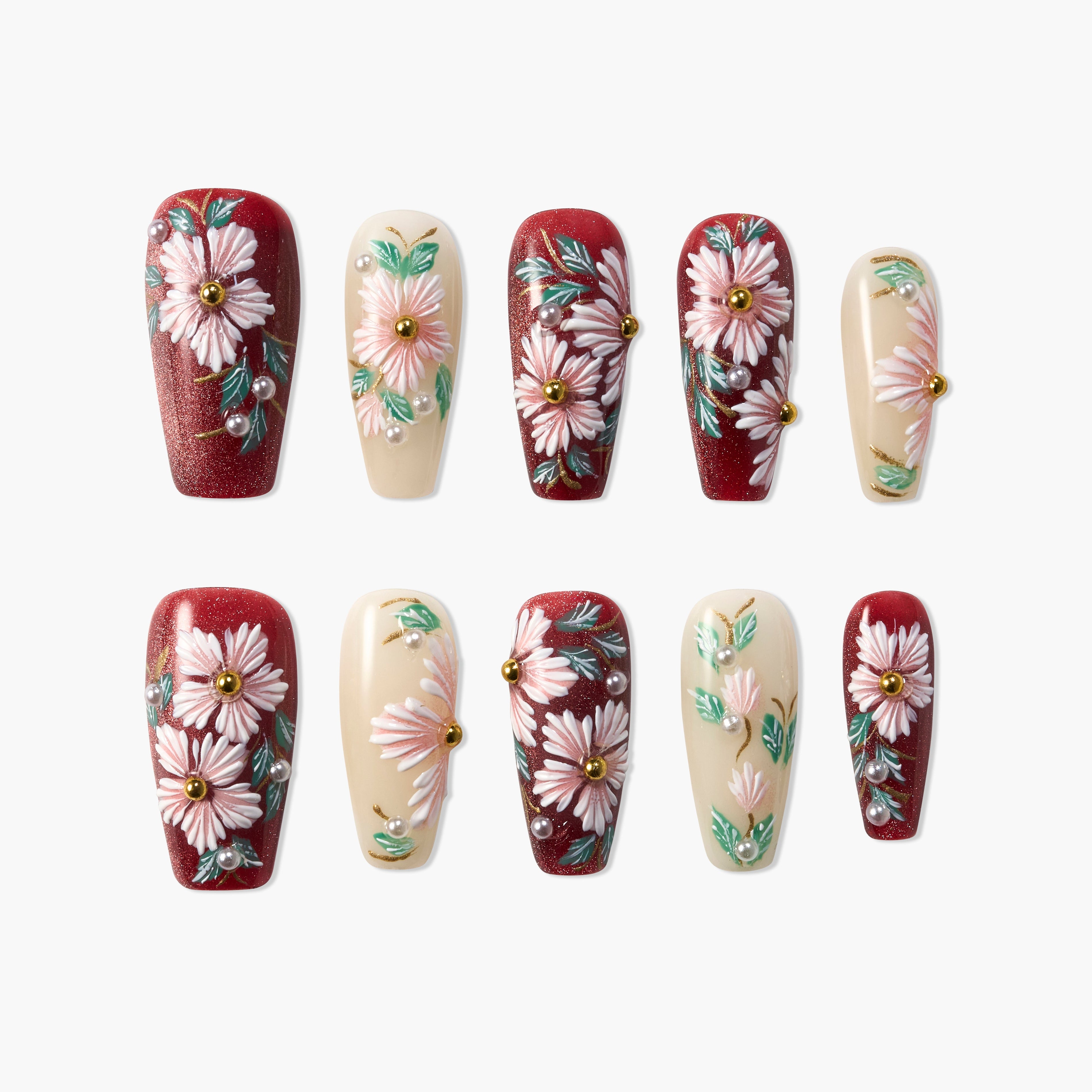 Handmade press-on nails with red and cream base, pink floral designs, and pearl accents