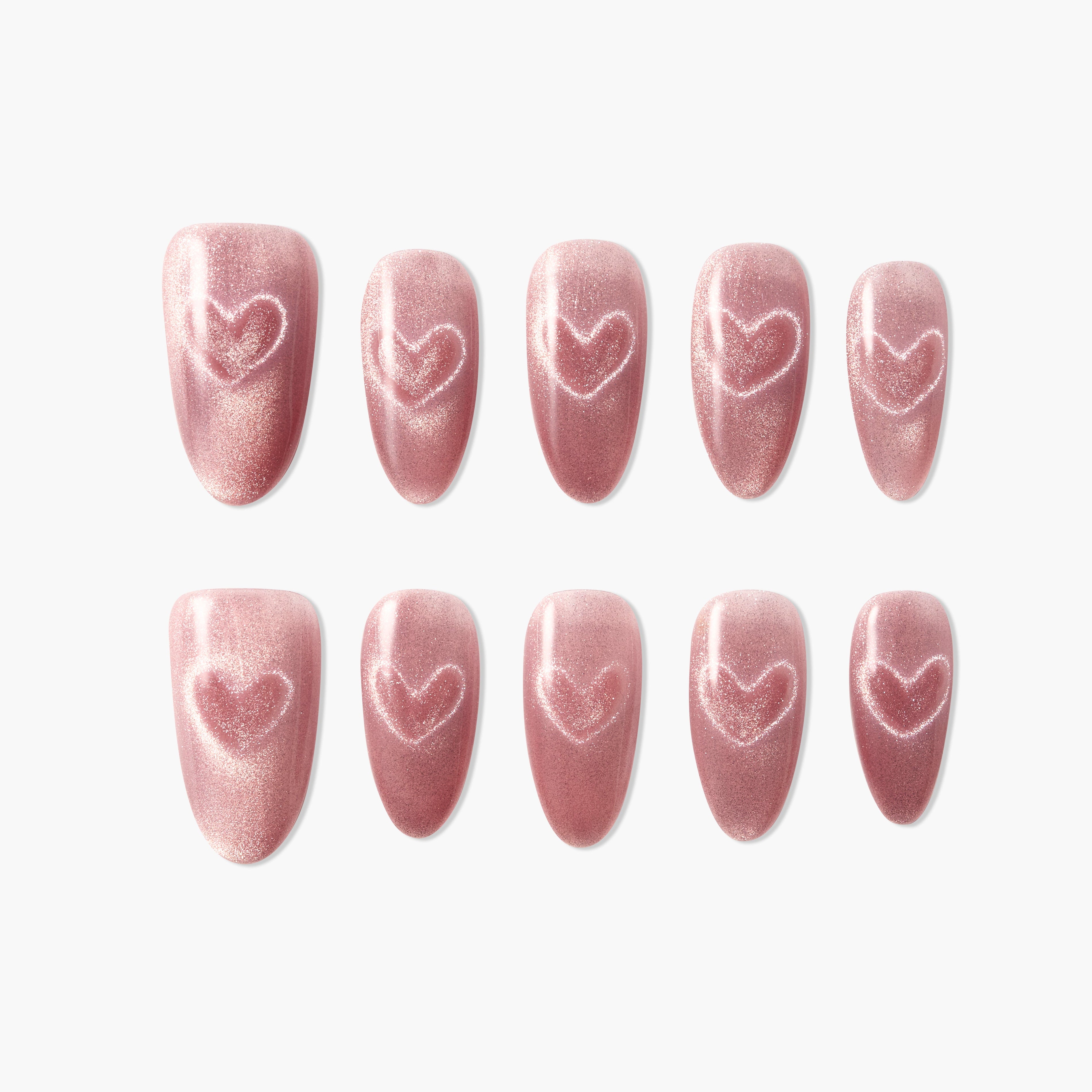 Set of shimmery pink press-on nails with heart design on white background