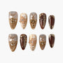 Handmade press-on nails set with gold, brown, and nude tones, featuring 3D florals and gems.