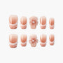 Handmade blush pink press-on nails with 3D floral pearl accent and white gradient tips.
