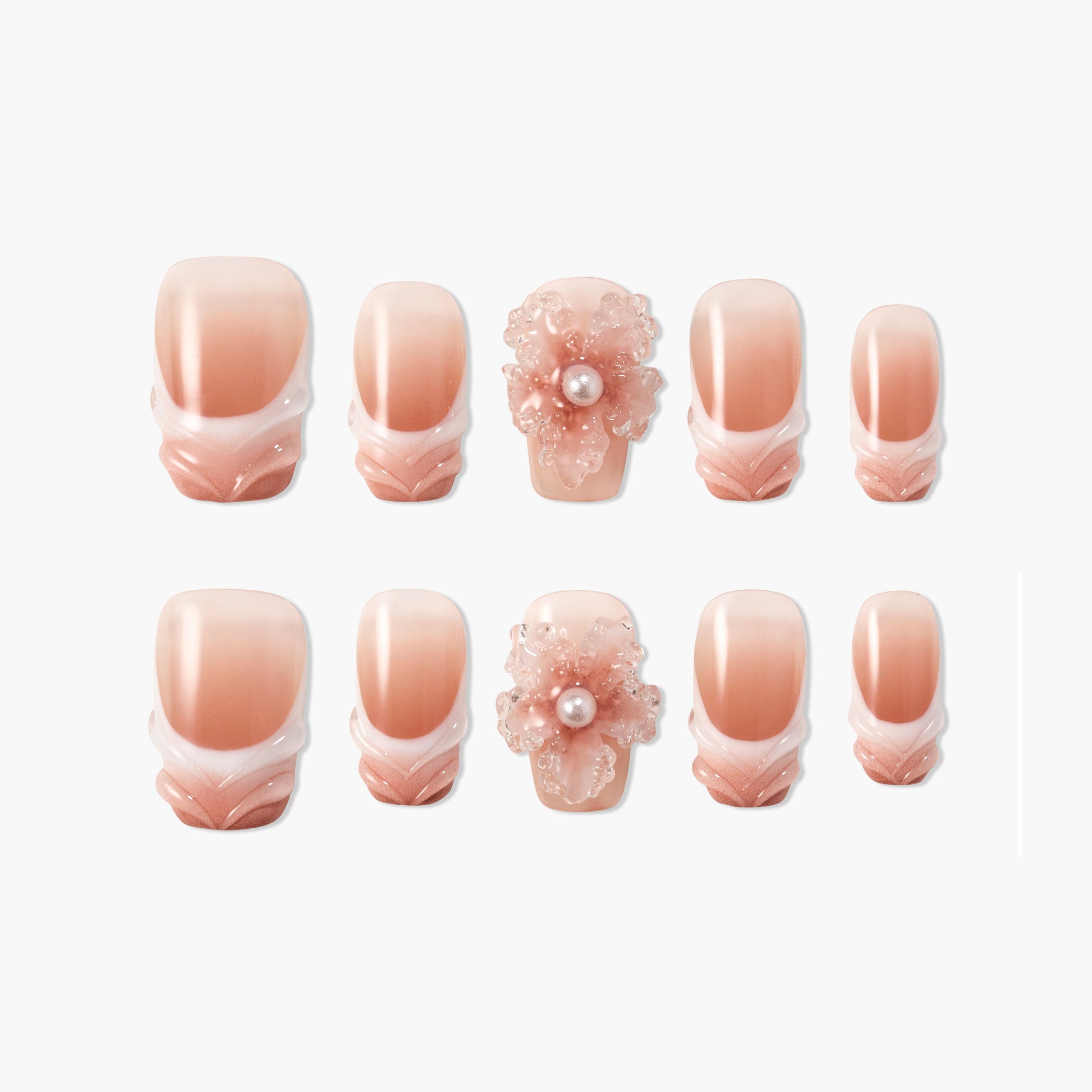 Handmade blush pink press-on nails with 3D floral pearl accent and white gradient tips.