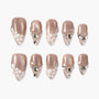 Set of nude shimmer press-on nails with white and silver 3D floral and gem designs.