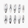 Set of white press-on nails with silver abstract metallic swirl design, coffin shape