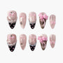 Handmade pink glitter press-on nails with 3D bows, pearls, rhinestones, and polka dot tips