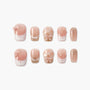 Pink and nude press-on nails with bows, pearls, glitter, and checkered designs on a white background