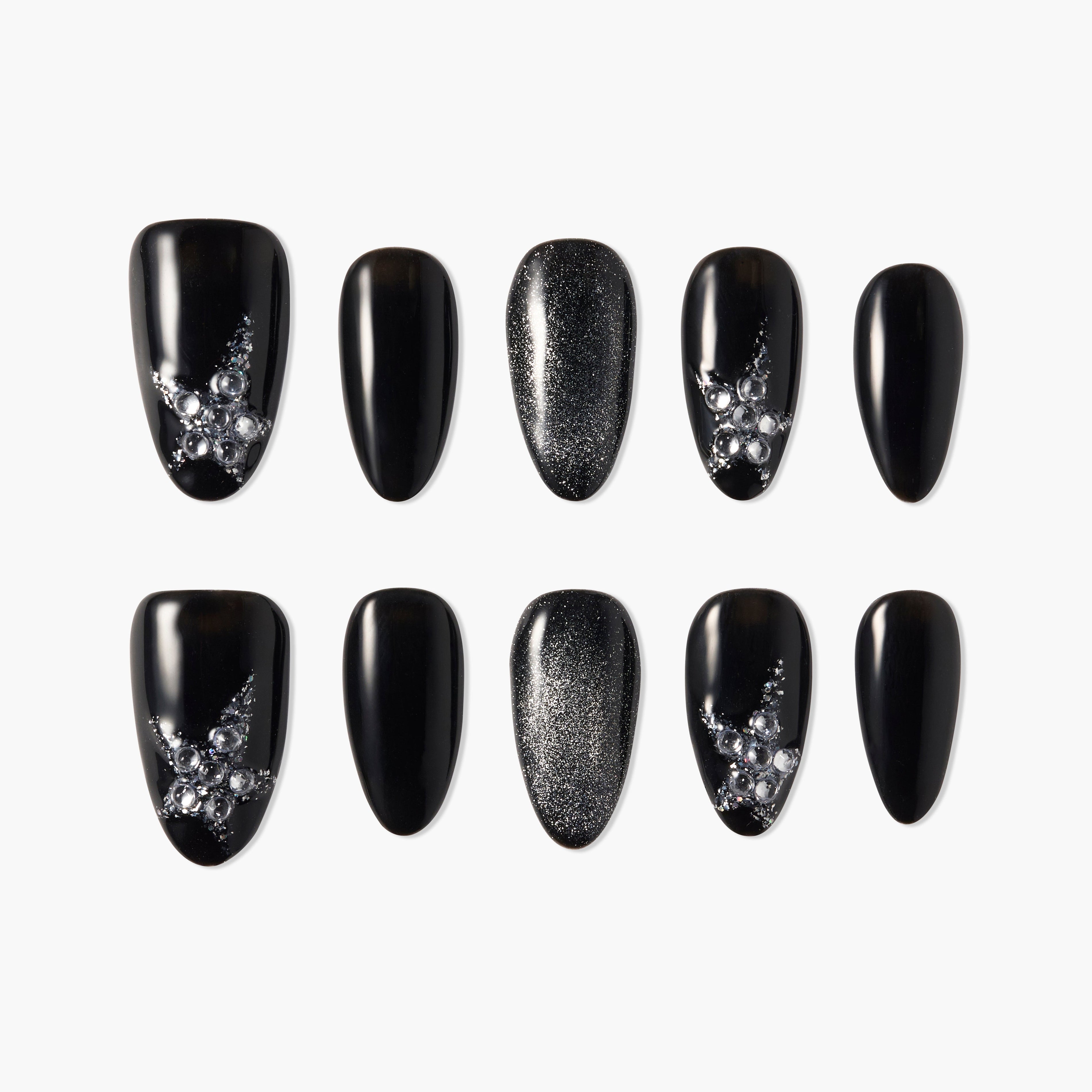 Black press-on nails with glitter and rhinestone star designs, arranged on a white background.