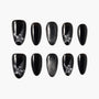 Black press-on nails with glitter and rhinestone star designs, arranged on a white background.