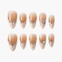 Handmade press-on nails with nude ombré base, floral accents, and rhinestone details.