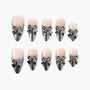Handmade press-on nails with silver metallic bow accents on nude and black ombré base