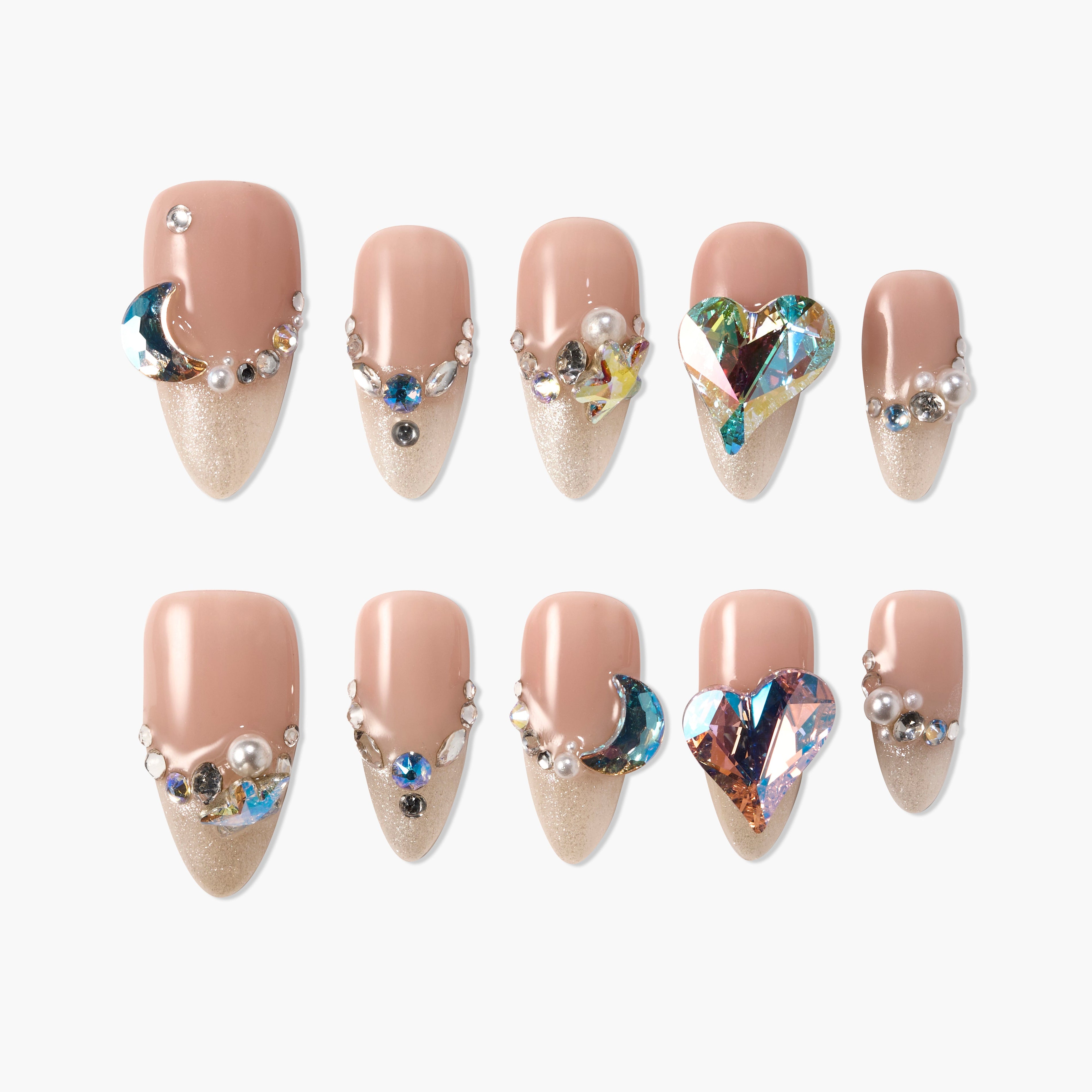 Nude and gold press-on nails with glitter, rhinestones, pearls, moon and heart gems