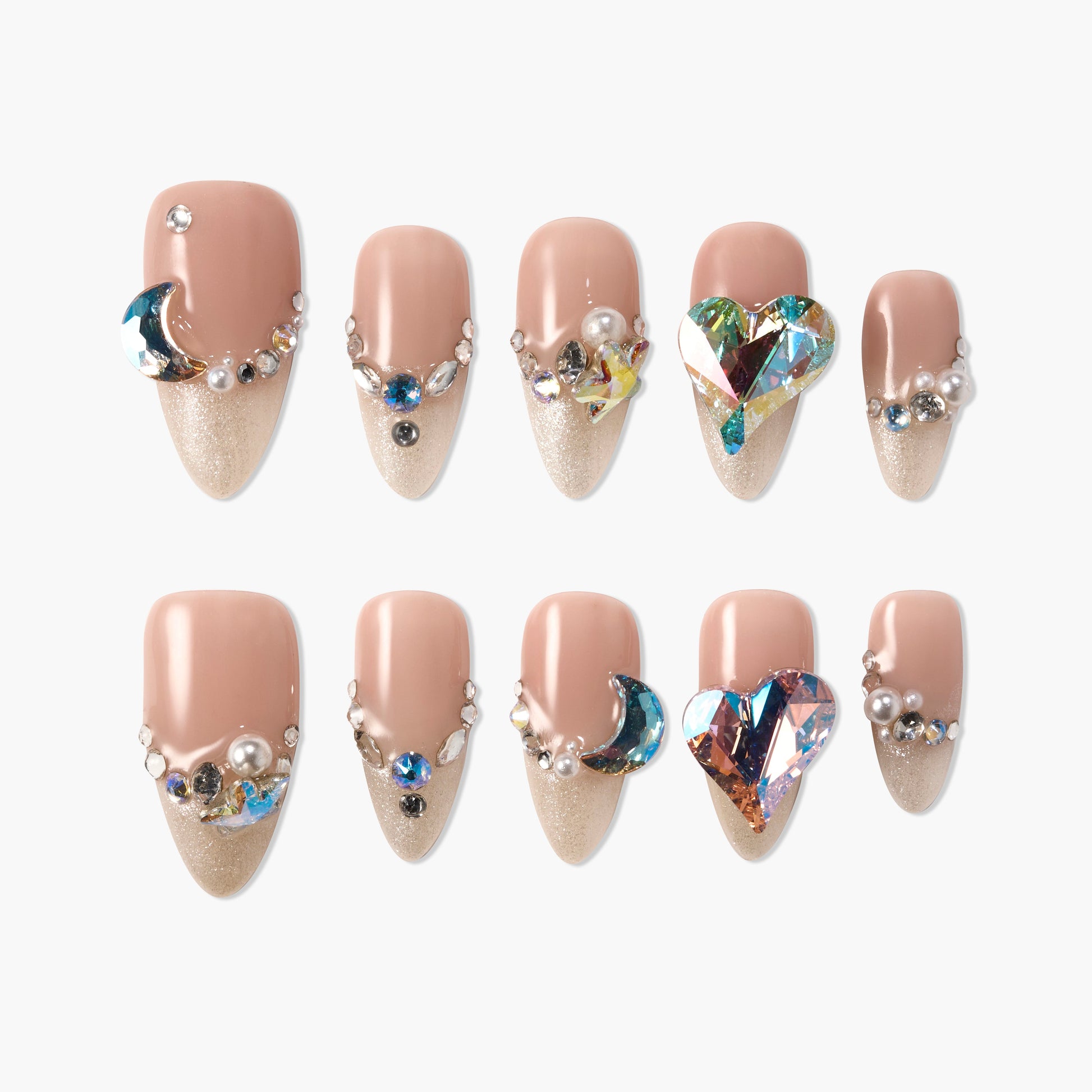 Nude and gold press-on nails with glitter, rhinestones, pearls, moon and heart gems