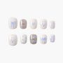 Handmade press-on nails with blue bows, hearts, dog faces, plaid, and fun lettering on white