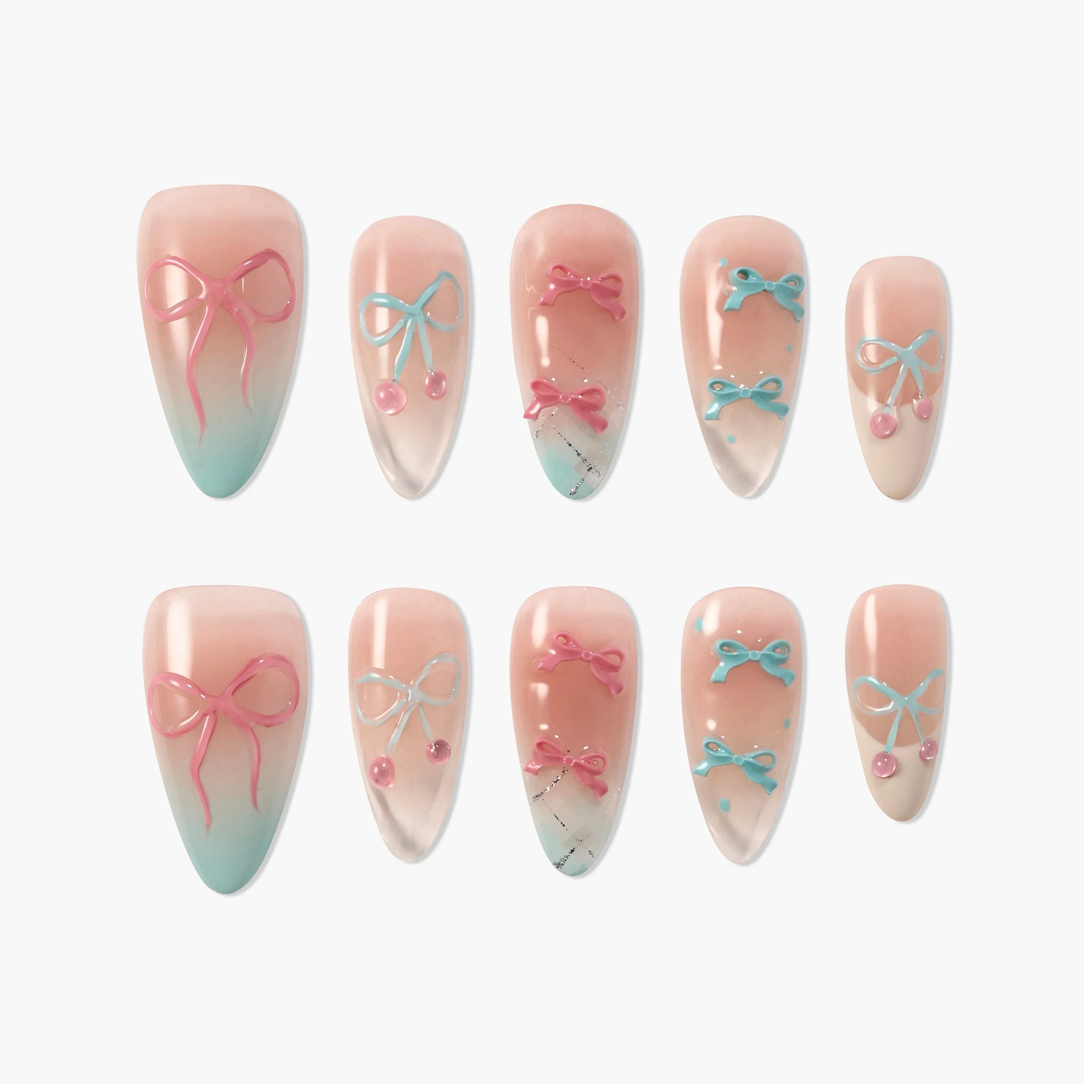 Handmade press-on nails with pink and blue bow designs on a nude and ombre base, arranged in a set.