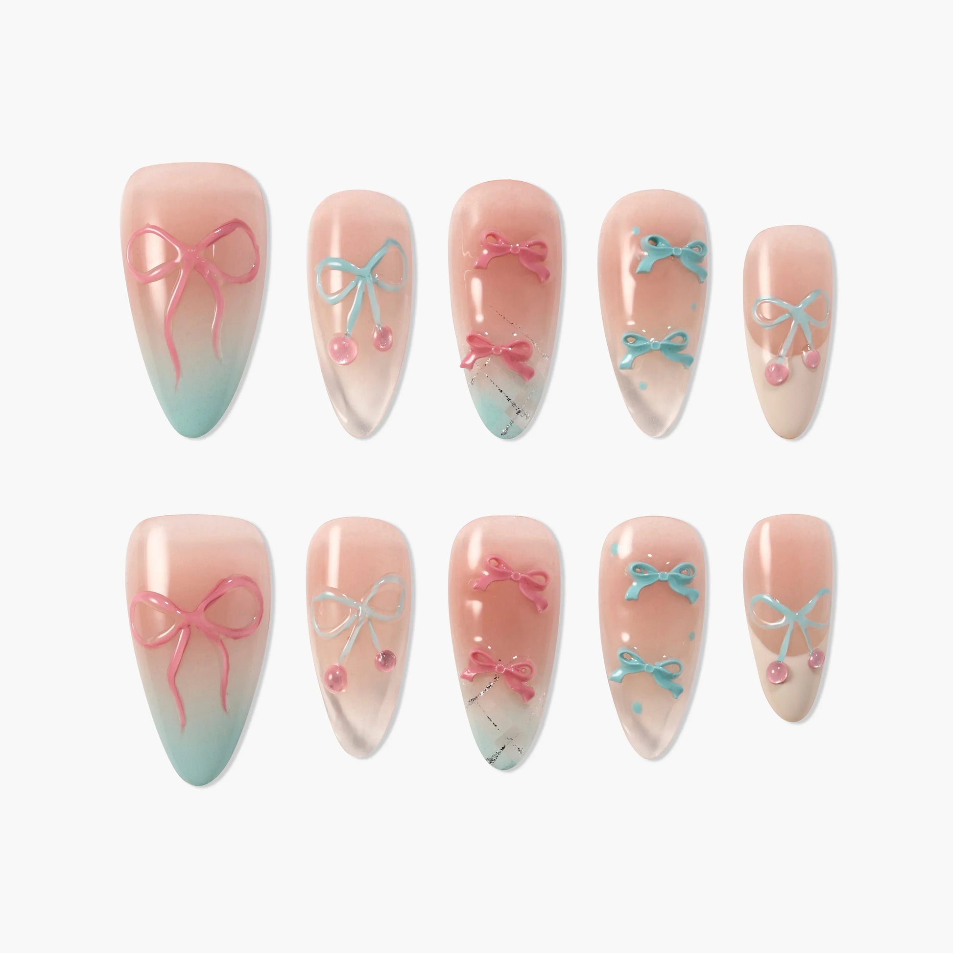 Handmade press-on nails with pink and blue bow designs on a nude and ombre base, arranged in a set.