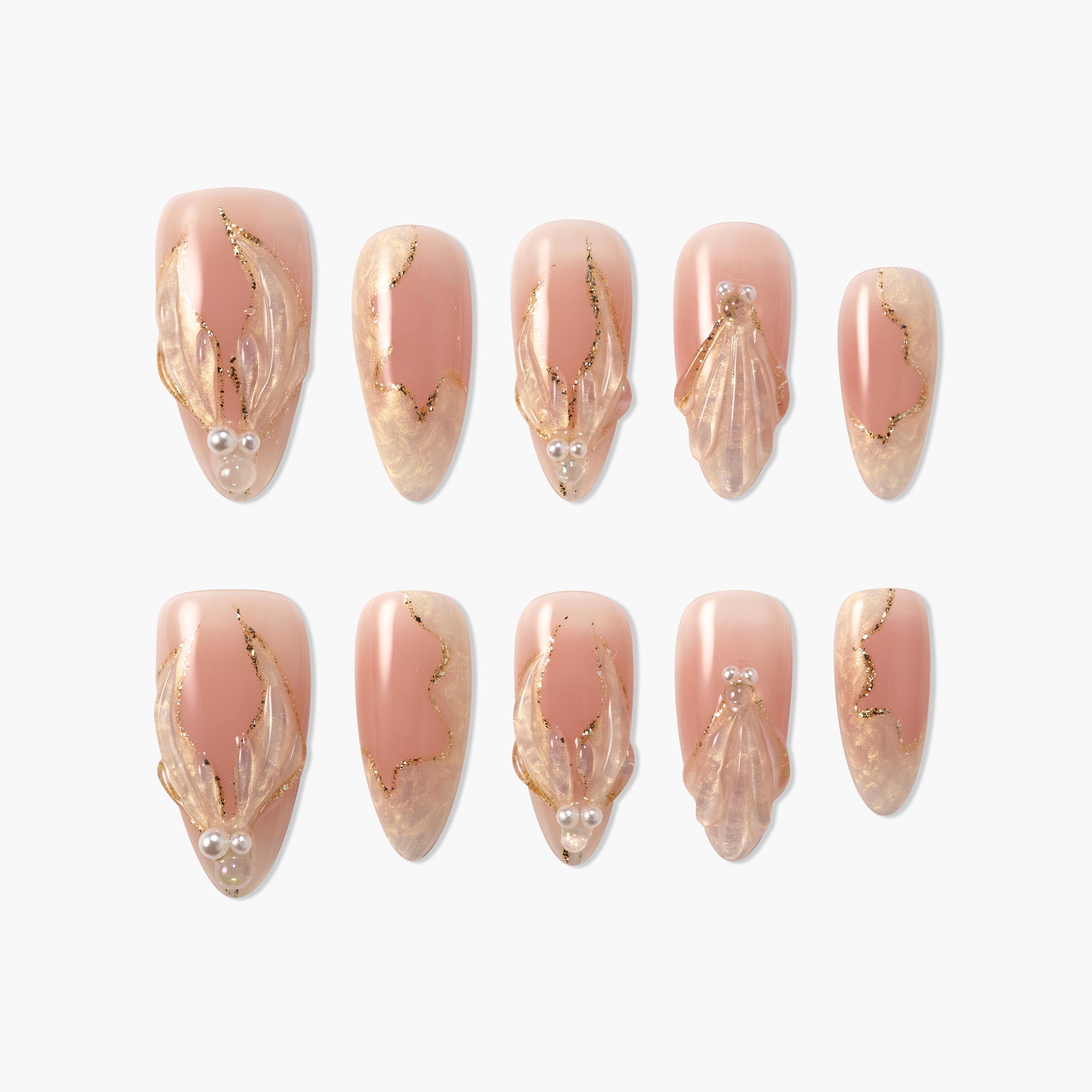 Handmade press-on nails in nude pink with 3D gold accents, pearl details, and marble design