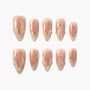 Handmade press-on nails in nude pink with 3D gold accents, pearl details, and marble design