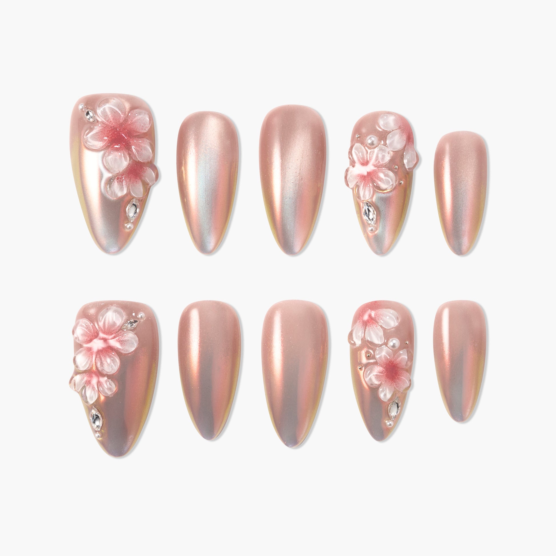 Iridescent pink press-on nails with 3D floral designs and rhinestone accents, displayed on white background.