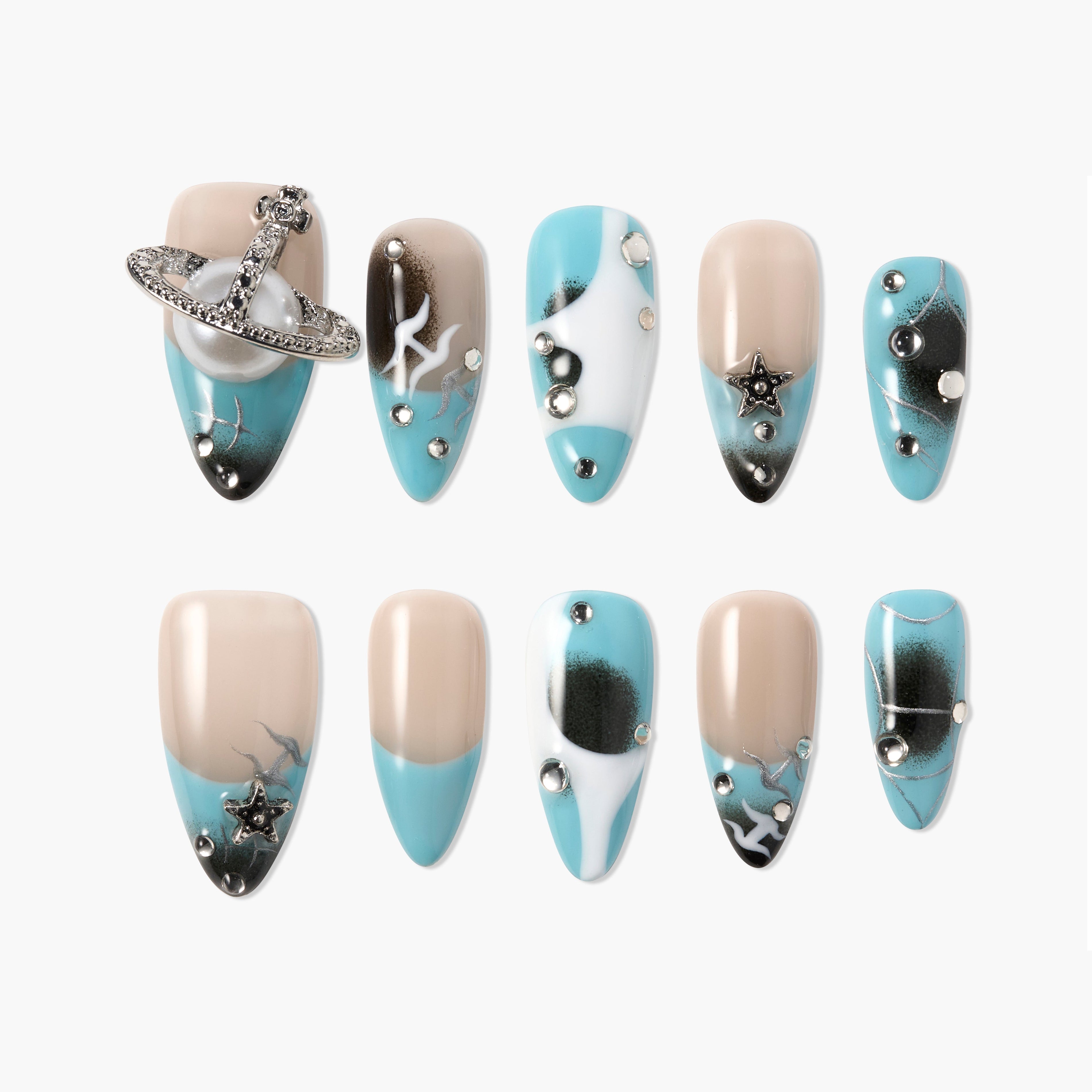 Blue and nude press-on nails with star and planet charms, rhinestones, and galaxy designs.