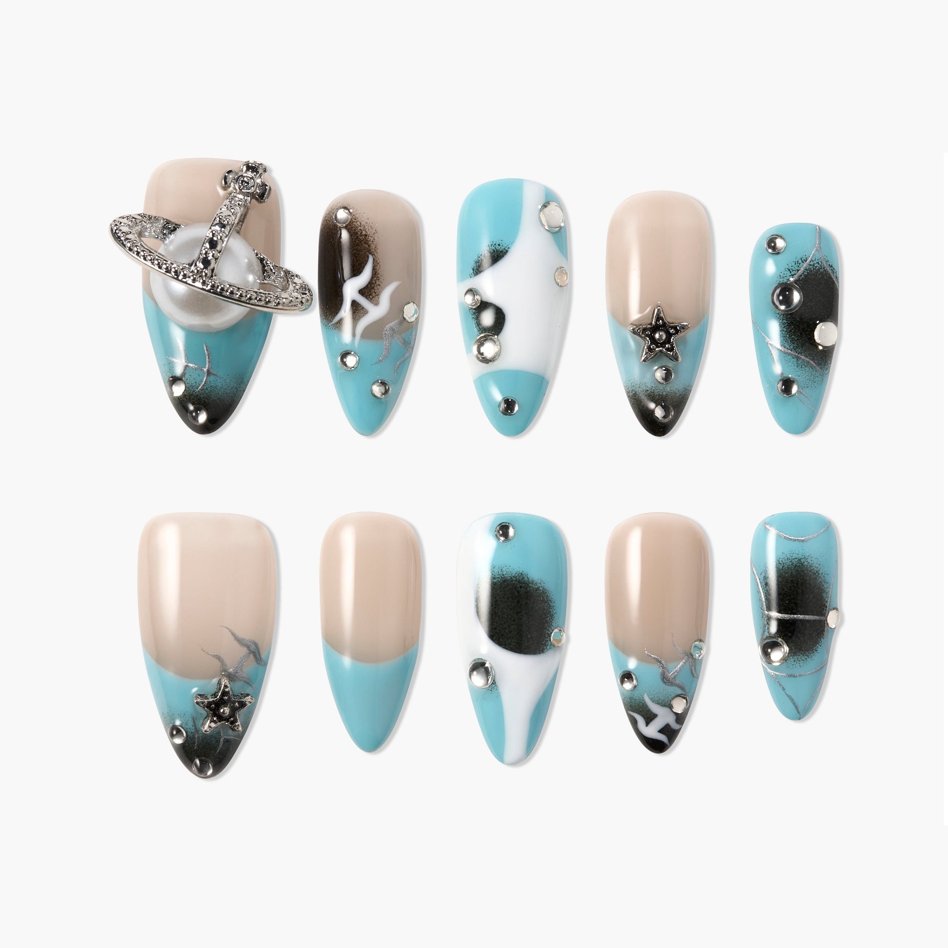 Blue and nude press-on nails with star and planet charms, rhinestones, and galaxy designs.