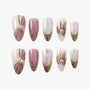 Handmade press-on nails with pink, gold glitter, pearl accents, and floral designs